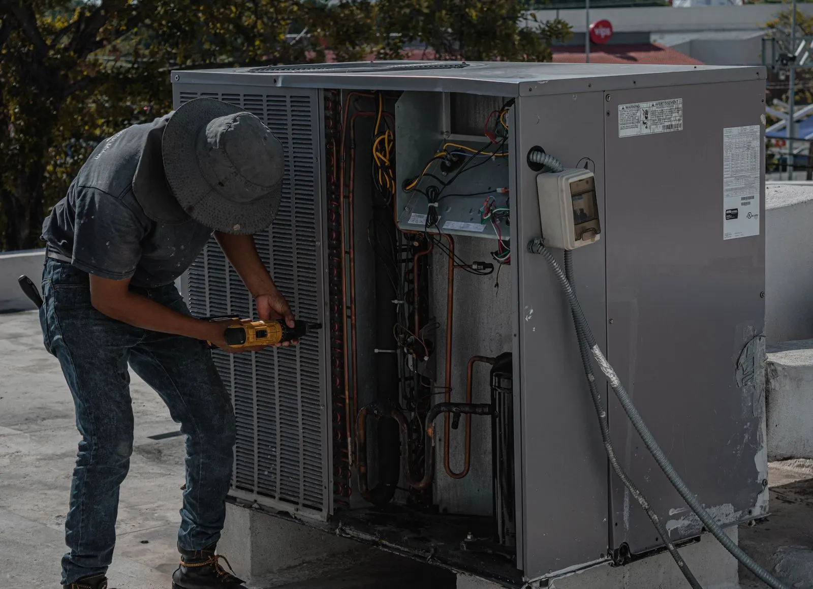 HVAC technician at work on a rooftop unit